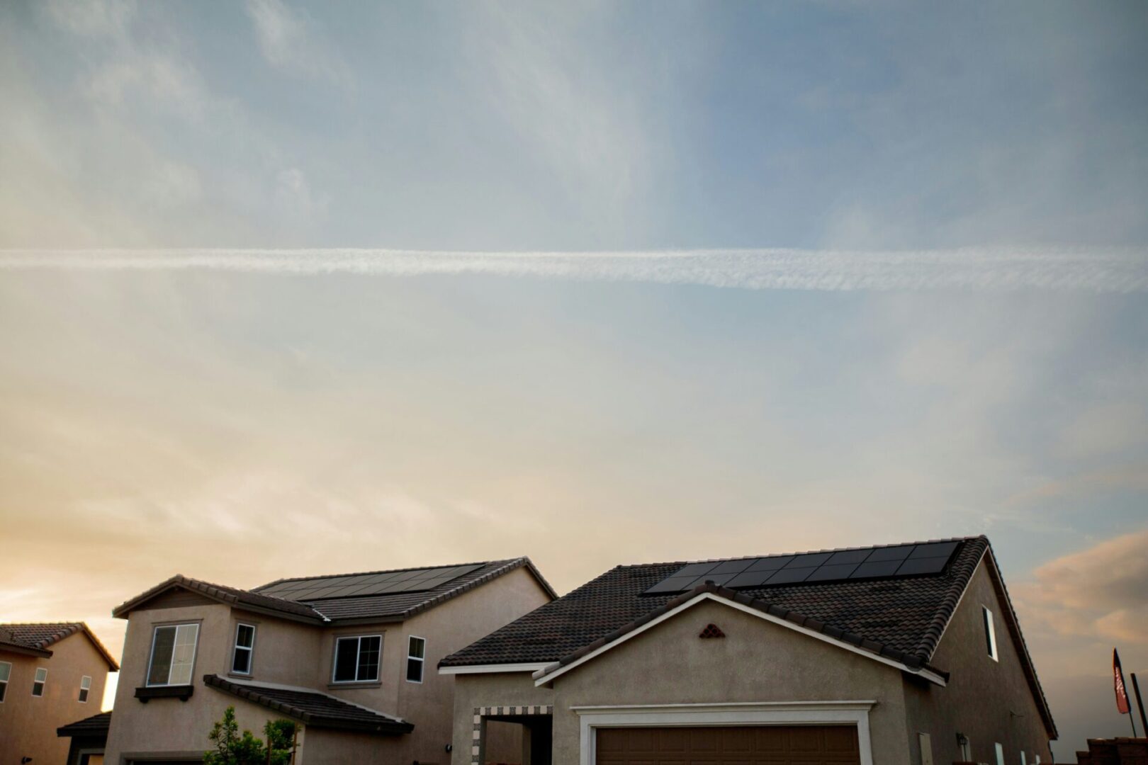 A house with two garage doors and a sky background